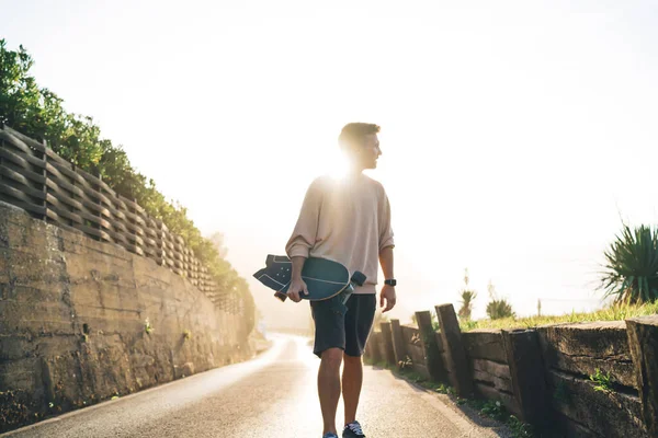 Alulról Magabiztos Férfi Alkalmi Ruhákban Sétál Kikövezett Ösvényen Longboarddal Kezében — Stock Fotó