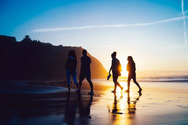 Groep Van Vier Vrienden Rug Verlicht Verlaten Strand Tijdens Het — Stockfoto