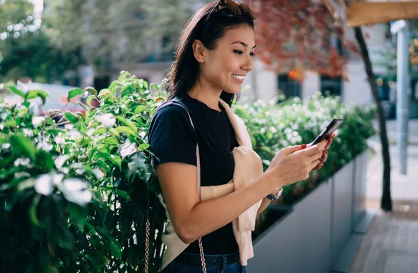 Uśmiechnięta Azjatycka Kobieta Trendy Casual Wear Przeglądanie Informacji Kawiarniach Ulicy — Zdjęcie stockowe