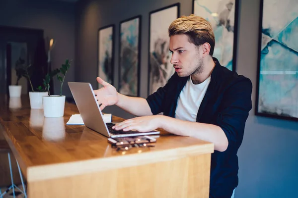 Joven Disgustado Con Ropa Casual Gesticulando Navegando Datos Ordenador Portátil — Foto de Stock