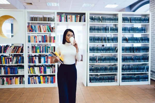 Kahvesini Yudumlayan Asyalı Kız Öğrenci Kütüphanenin Kısımlarında Defter Tutuyor — Stok fotoğraf