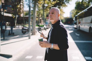 Kafkas erkek son sınıf öğrencisi, bilgi taraması ve kafein içeceği ile paket servis kupası, dijital tabletli 60 'lı blogger günlerini şehir sokaklarında geçirmek için kahve tutarak geçiriyor.