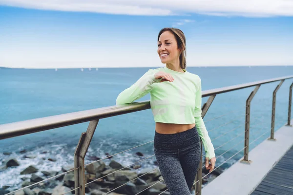 Cheerful Sportswoman Dressed Comfortable Tracksuit Standing Seashore Pier Smiling Workout — Stok fotoğraf
