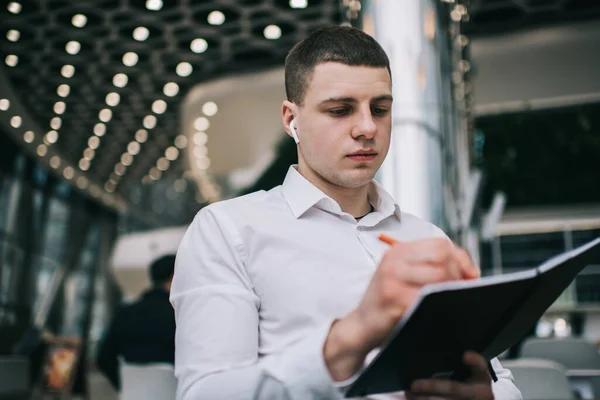 Junger Geschäftsmann Weißem Bürohemd Der Notizbuch Schreibt Während Einem Modernen — Stockfoto