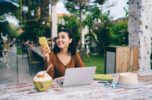 Optimistic Asian Female Using Mobile Phone Sitting Laptop Cafe While — Fotografia de Stock