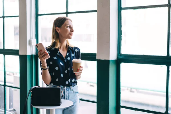 Positiv Kaukasisk Kvinna Trendig Klädsel Stående Café Interiör Håller Mobiltelefon — Stockfoto