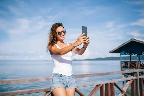 Wesołe Tysiąclecia Dziewczyna Stylowych Okularach Przeciwsłonecznych Pomocą Telefonu Komórkowego Selfie — Zdjęcie stockowe