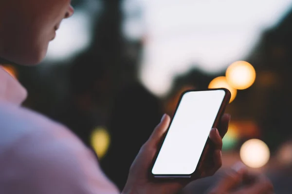 黄昏时分站在街上用空屏幕浏览手机的无名小卒女 在模糊的背景下为短信做广告 — 图库照片