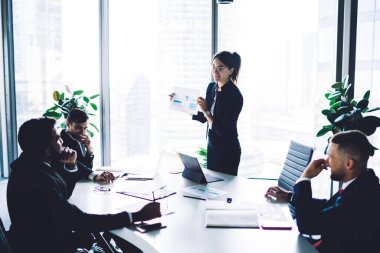 Arama stratejisi çözümleri için beyin fırtınası konferansı sırasında başarılı şirket çalışanlarından oluşan resmi giyim eğitim grubu yöneticisi, neşeli finans uzmanları sözleşmeden bahsediyorlar.