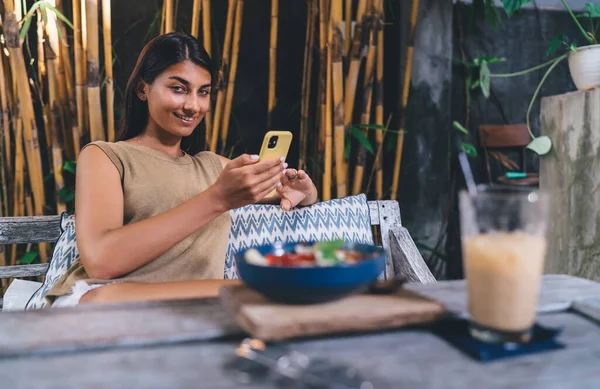 Usmívající Etnická Žena Procházení Smartphone Posezení Stolu Pitím Salátem Při — Stock fotografie