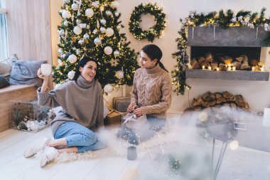 Heyecanlı kadınların elinde kutular ve bardaklar dolusu sıcak içecekle Xmas kutlama partisinin planlarını tartışmalarından.