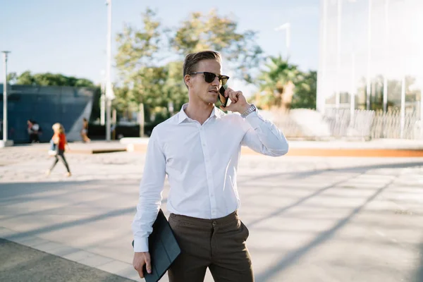 身着时髦服装 戴着太阳镜 带着漫游的商人 通过智能手机应用程序与老板 白种人男性员工通过数字平板电话进行国际交流 — 图库照片
