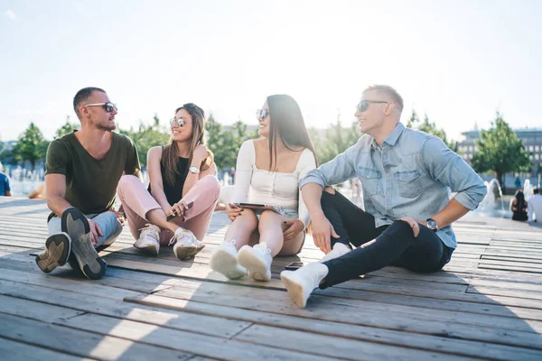 Jóvenes Gafas Sol Modernas Charlando Mientras Están Sentados Parque Con —  Fotos de Stock