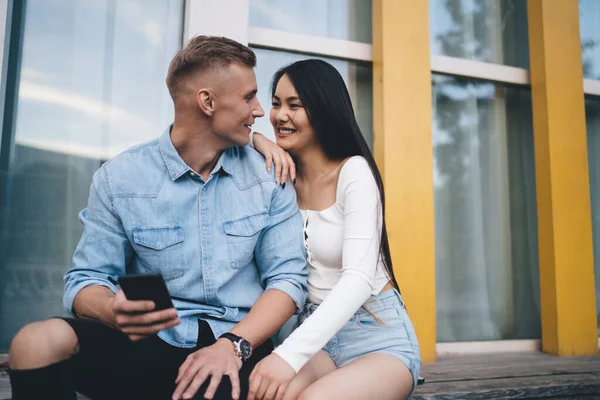 Vrolijke Multi Etnische Paar Casual Dragen Zitten Houten Bank Kijken — Stockfoto