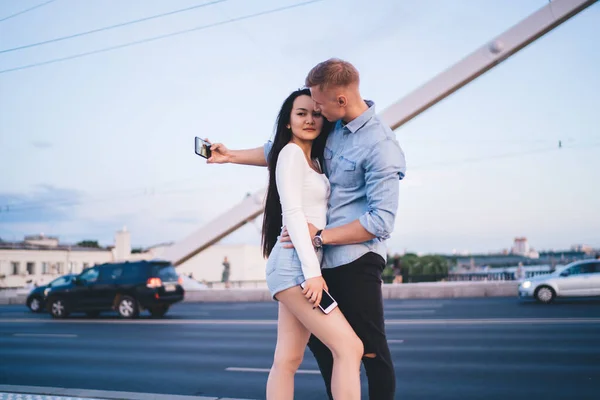 Joven Abrazando Novia Mientras Usa Dispositivo Moderno Para Tomar Fotos — Foto de Stock