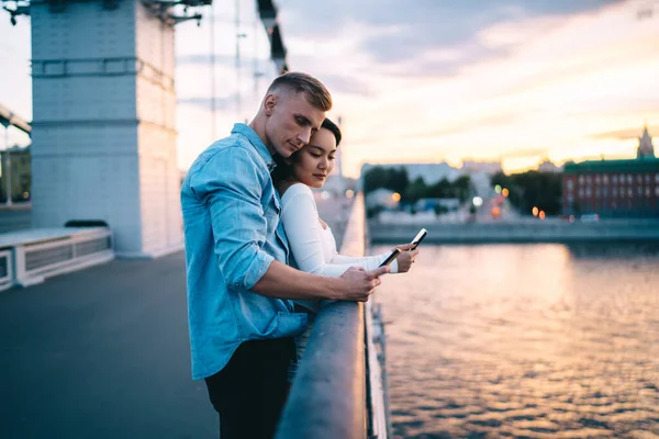 Vista Lateral Jovem Casal Bonito Diversificado Usando Smartphones Enquanto Está — Fotografia de Stock