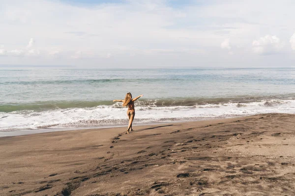 Задний Вид Анонимной Женщины Поднятыми Руками Купальнике Прогуливающейся Песчаному Пляжу — стоковое фото