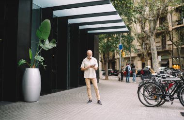 Kafkas erkek turist emekliliğinde, tatillerde GPS 'i takip etmek için modern dokunmatik rampa kullanıyor, gündelik kıyafetleri olan yetişkin bir adam cihazla 4G kablosuz internete bağlanıyor.