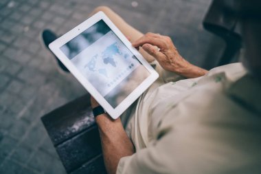 Görüntülenen konum haritasını kontrol etmek için modern dokunmatik ekranda 4G kablosuz internete bağlanan tanınamayan erkek kullanıcı, kırpılmış adam dijital tablet arama medya dosyasına göz atmak için dokunuyor