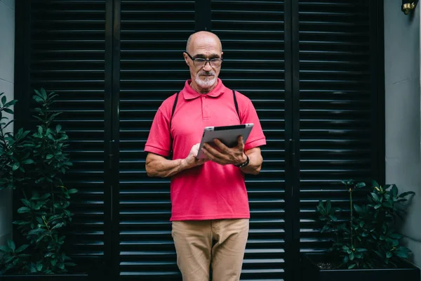 Çevrimiçi modda sohbet ve mesajlaşma için 4G 'ye bağlanan yaşlı blogcu, klasik gözlüklü son sınıf öğrencisi, kentte ayakta duran modern dokunmatik bloknotlardan e-posta aldı