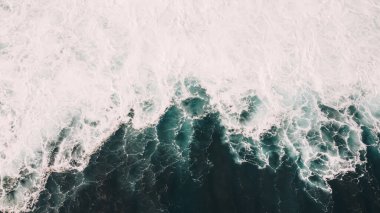 Dışarıdaki lagünün fırtınalı havası sırasında açık gök mavisi deniz manzarası ve güneş ışığı altında dönen insansız hava aracı manzarası.