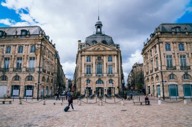Soğuk yaz gününde Fransa 'nın Bordeaux kentindeki kalabalık meydanında eski mimarisi olan yaşlı taş binaların altından.
