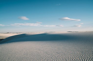 Beyaz Kumlar Ulusal Parkı 'ndaki kumlu kum tepelerinin resimli çöl manzarasından güneşli bir günde mavi bulutlu gökyüzüne karşı