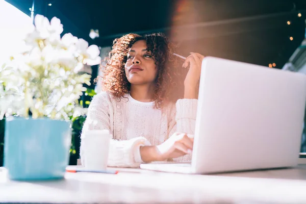 美丽而沉思的深色皮肤嬉皮士女学生通过咖啡馆平台上的技术在网上学习 迷人而集中的非洲女性博客作者思考媒体内容的想法 — 图库照片