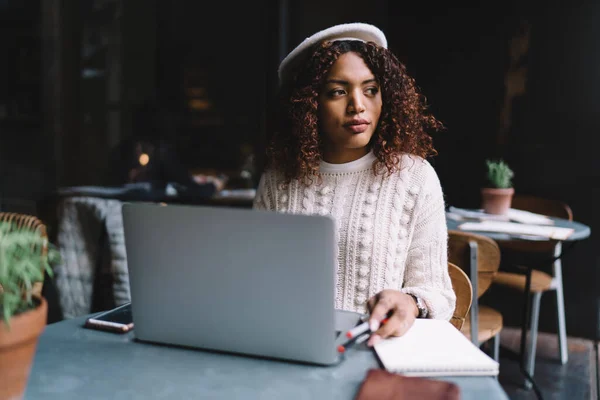 Konzentrierte Junge Schwarze Freelancerin Pullover Und Trendiger Baskenmütze Mit Laptop — Stockfoto