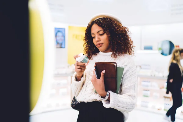 Pensive Trendy Oblečený Africký Američan Žena Kontrolu Složek Chemikálií Krém — Stock fotografie