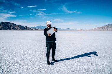 ABD 'de siber uzayı keşfederken genişletilmiş çıkıntıların yakınında VR kulaklıklı tanımlanamayan bir erkeğin tüm vücudu.