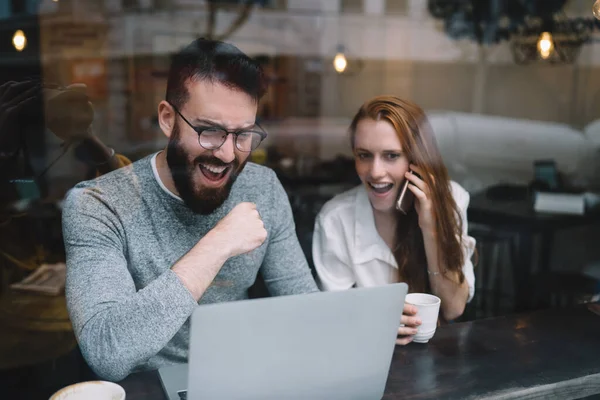 Emocionada Pareja Joven Ropa Casual Viendo Portátil Mientras Está Sentado —  Fotos de Stock