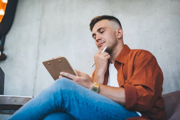 Niedriger Winkel Eines Jungen Nachdenklichen Mannes Mit Stift Und Klemmbrett — Stockfoto