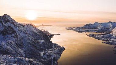 Kışın karla kaplı görkemli fiyort dağlarının nefes kesici kuş bakışı görüntüsü. Hava manzaralı kaya zirveleri, resim gibi güzel doğa manzarası. Lofoten Adası İskandinav Denizi ile çevrilidir
