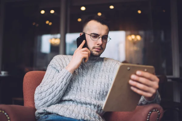 Gedachte Bebaarde Mannelijke Freelancer Casual Kleding Bril Praten Mobiele Telefoon — Stockfoto