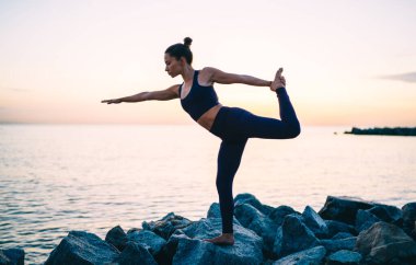 Natarajasana 'da rahat bir beyaz kadın, sağlıklı yaşam tarzını ve sağlığını koruyor, spor ve yoga eğitiminden zevk alan esnek bir kadın vücudunu ve canlılığını koruyor.