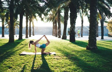 Kafkas kadın, yükseltilmiş bacağıyla Asana 'yı yapıyor vücudunu formda tutmaya odaklanmış, yoga eğitiminden zevk alan kadın, sabah güneş doğarken dinlenme sırasında enerji almak için doğanın verdiği ilhamı hissediyor.