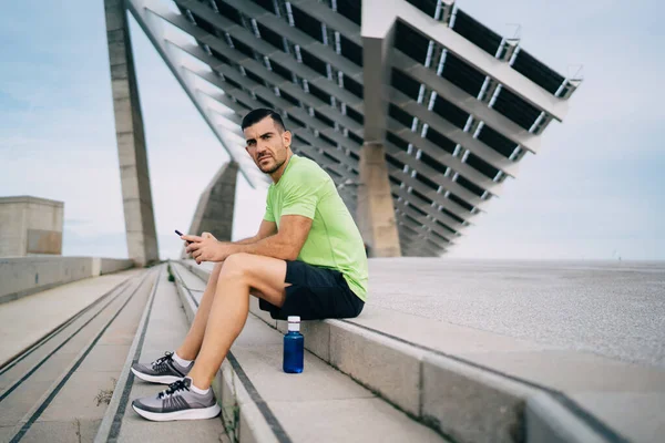 Porträtt Ung Kaukasisk Atletisk Löpare Med Mobiltelefon Gadget Händerna Vilar — Stockfoto