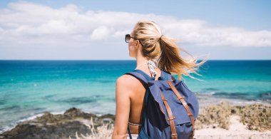 Menorca 'nın sahil şeridinde duran güzel deniz manzarasına bayılan kadın turistin arka planı. İspanyol yalnız başına doğayla ilgili tatillerde dinlenen kaygısız kadın.