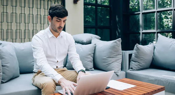 以男性企业家为主要对象 在工作时穿着网簿 坐在舒适的沙发上 在咖啡店里工作 — 图库照片