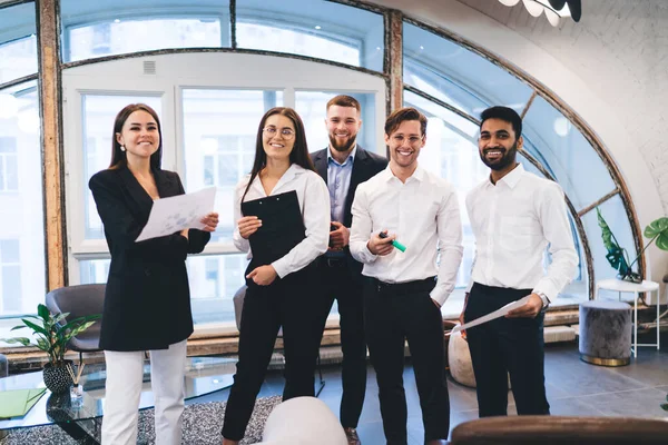 Jóvenes Mujeres Sonrientes Con Papel Carpeta Pie Cerca Parejas Masculinas — Foto de Stock