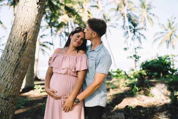 Young Content Man Kissing Embracing Charming Pregnant Wife Stylish Pink — Stock Photo, Image
