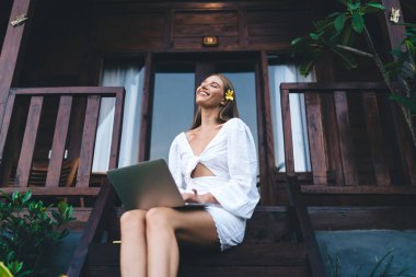 Tahta terasın merdivenlerinde oturan, dizlerinin üstüne çöküp iş sırasında gözlerini kapayan pozitif kadın işçilerden.