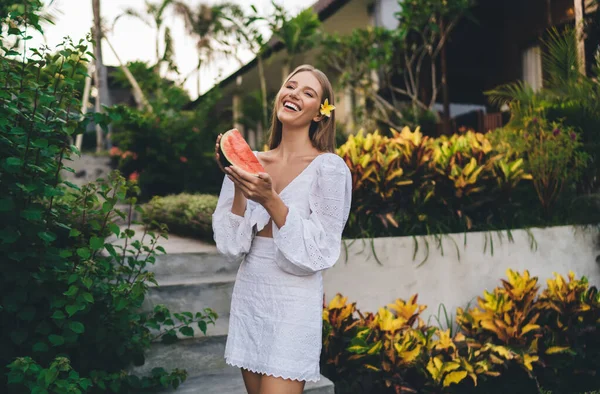 夏のリゾート旅行中に健康的な食べ物を楽しみながら 裏庭で凍える手でスイカの一片と幸せな女性観光客 — ストック写真