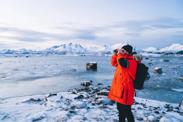 배낭을 노르웨이를 여행하는 눈덮인 산속의 속에서 쌍안경을 — 스톡 사진