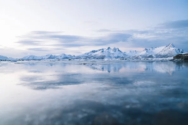 겨울에 노르웨이 피오르드의 구름낀 하늘을 배경으로 눈덮인 산등성 로둘러싸인 얼어붙은 — 스톡 사진