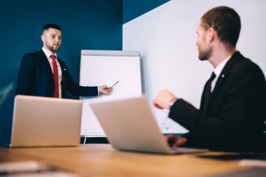 Modern konferans odasındaki sunum sırasında meslektaş için işleri anlatırken resmi kıyafetli genç ve zarif girişimcinin düşük açılı görüntüsü