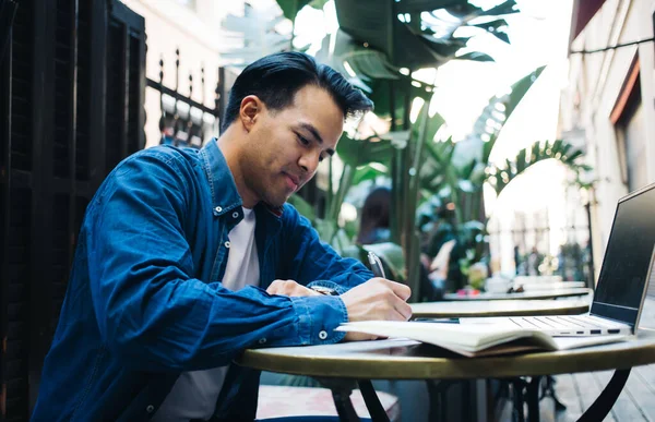 Sett Fra Siden Ung Smilende Mannlig Fjernarbeider Som Noterer Seg – stockfoto