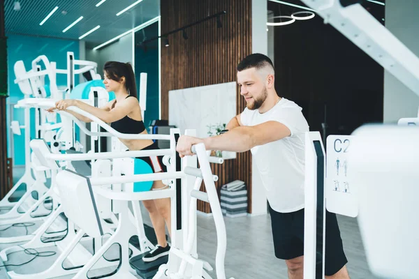 Slim Jovens Desportistas Concentrados Vestindo Treinamento Activewear Máquina Esportes Ginásio — Fotografia de Stock