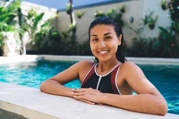 Mulher Hispânica Jovem Positiva Vestindo Maiô Piscina Perto Plantas Tropicais — Fotografia de Stock